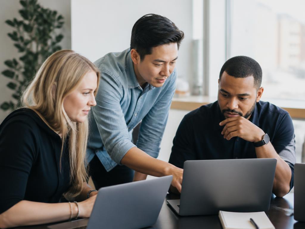 Ein Team arbeitet gemeinsam an Laptops und baut KI-Workflows